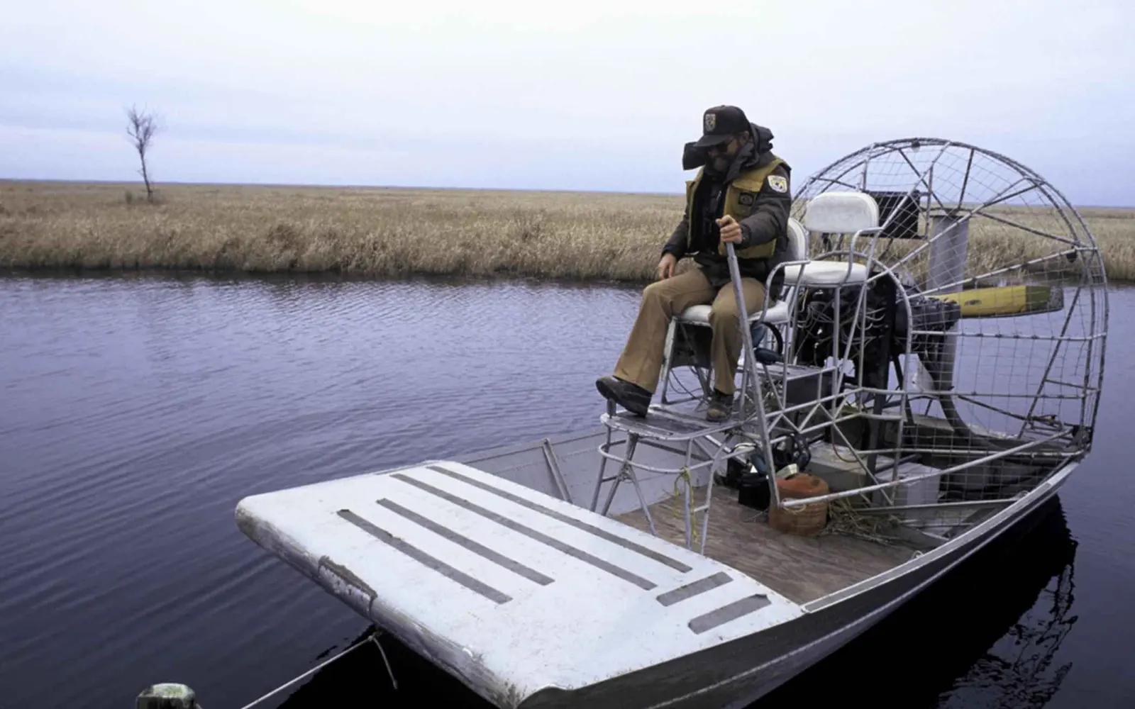 Airboat cutting through a Louisiana marsh channel